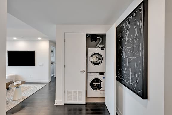 A modern laundry room with a washer and dryer built into the wall.