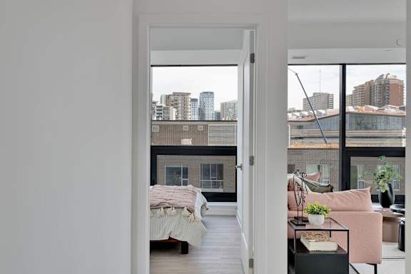A bedroom with a bed and a couch is visible through an open door.