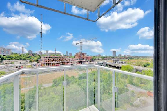A balcony view of a construction site with cranes and buildings under construction.