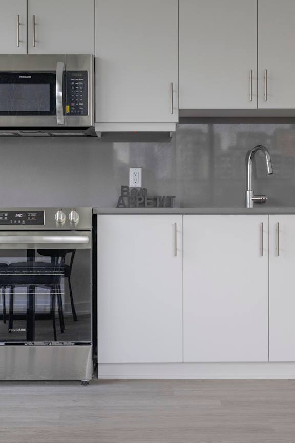 A kitchen with a stainless steel microwave above a stainless steel oven.