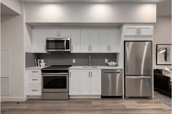 A modern kitchen with stainless steel appliances and white cabinets.