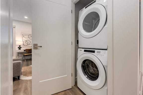 A white washing machine is in a small laundry room.