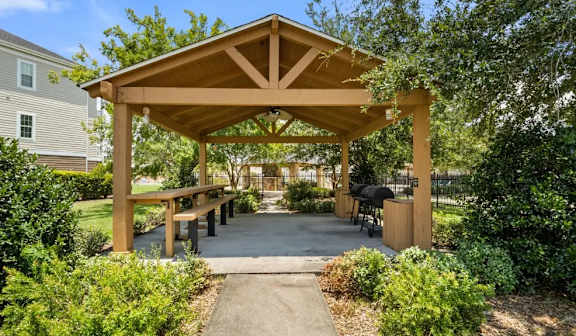 Covered outdoor pavilion with wooden beams and seating at Ansley Place Apartments, Louisiana