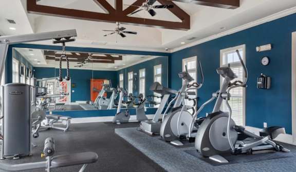 Fitness center with cardio equipment and mirrored wall at Ansley Place Apartments, Houma, Louisiana