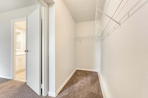A room with a carpeted floor and a white door.
