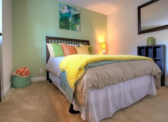 Bedroom at Town Place Apartments featuring carpeted flooring on first-floor bedrooms, with upper-floor homes offering carpeting throughout living areas except wet spaces.