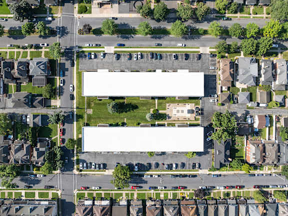 A large white building sits in the middle of a residential area.