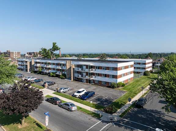 A parking lot in front of a multi-story apartment building.