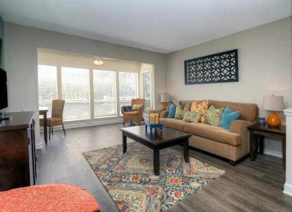 Spacious living room at Town Place Apartments featuring air-conditioned comfort, an open floor plan, and connection to the sunroom.