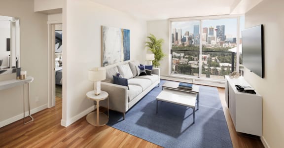 living toom with a couch, lamps, artwork, a TV and a balcony with a view