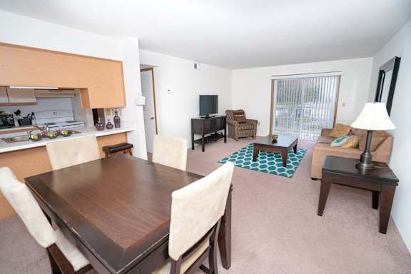 A dining room with a wooden table and chairs.