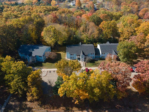 A house surrounded by trees with autumn leaves.