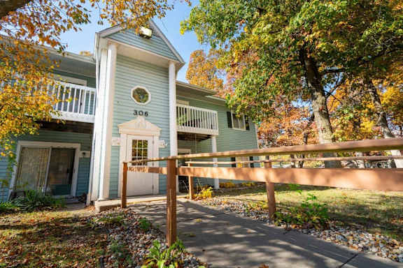 A house numbered 306 with a porch and a fence.