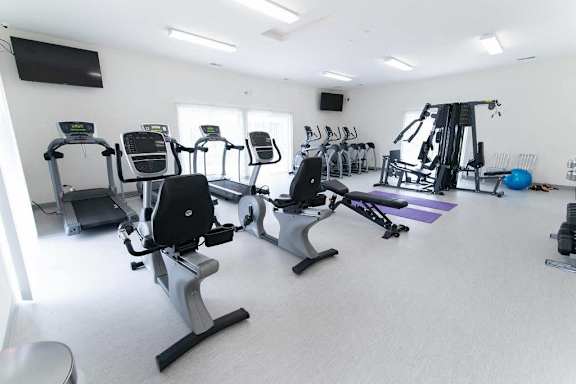 a gym with several machines and a tv
