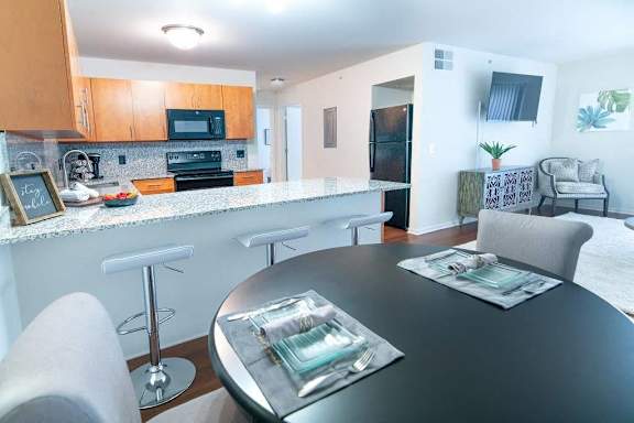 a kitchen and a dining room with a table and chairs