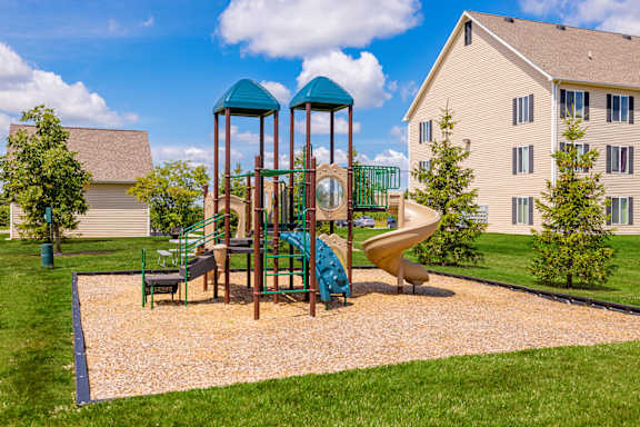 A playground with a slide, swings, and a roundabout.