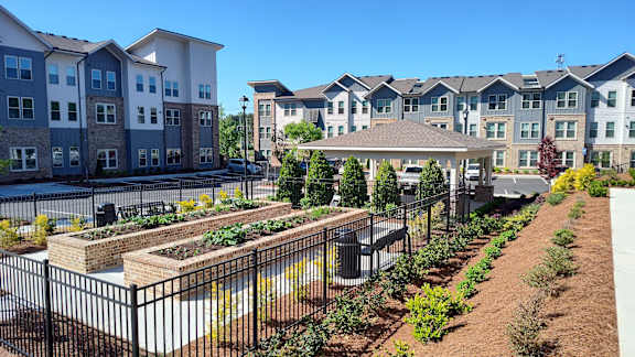 A view of apartment buildings with a garden in the foreground.