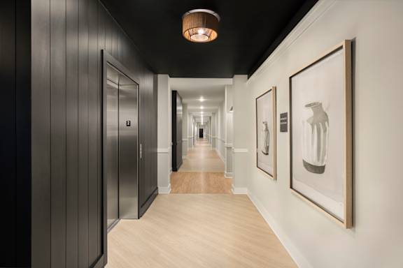 A hallway with a light on the ceiling and pictures on the wall.