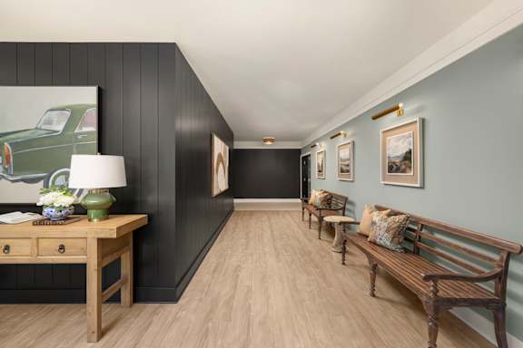 A long hallway with a bench and pictures on the wall.