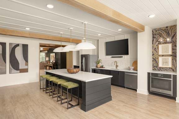 A modern kitchen with a large island and stools.