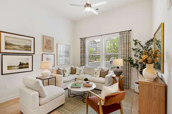 A living room with a white couch, a coffee table, and a painting on the wall.