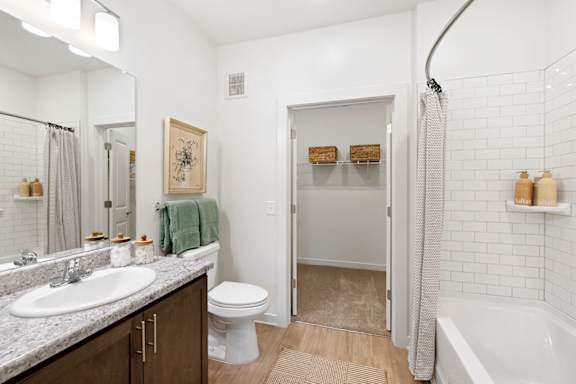 A white bathroom with a toilet, sink, and shower.