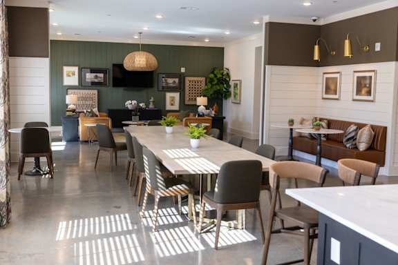 A modern dining room with a long table and chairs.