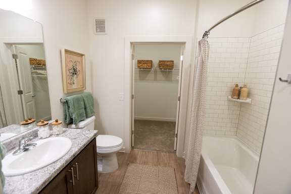 A bathroom with a white toilet, sink, and bathtub.
