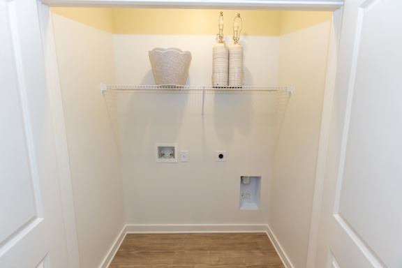 A small white closet with a shelf and two lights.