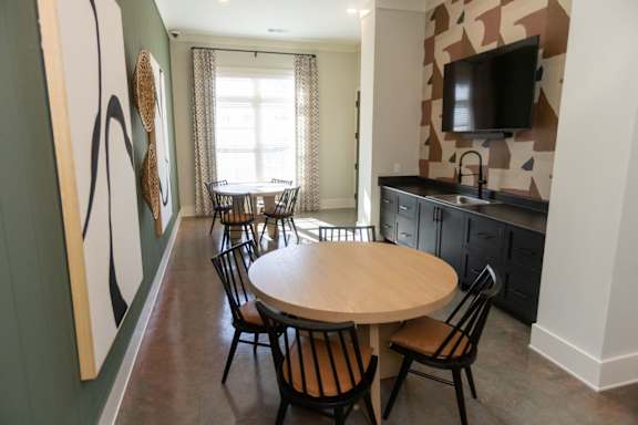 A dining room with a table and chairs.