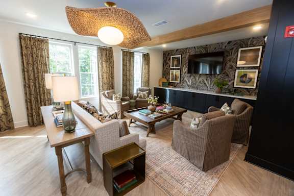 A living room with a lamp, couch, and chairs.