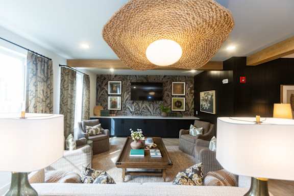 A living room with a large lamp and a sofa.