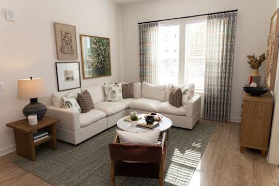 A living room with a white couch and a wooden coffee table.