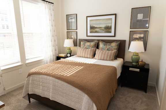A bedroom with a large bed and a painting on the wall.