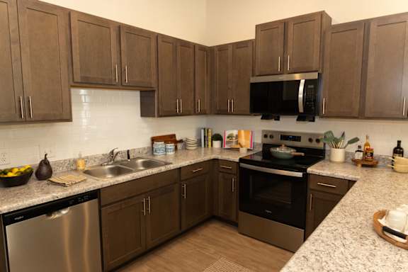 A kitchen with brown cabinets and stainless steel appliances.