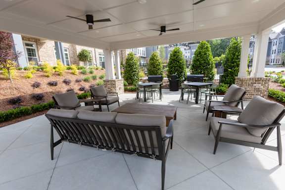A patio with a table and chairs under a roof.