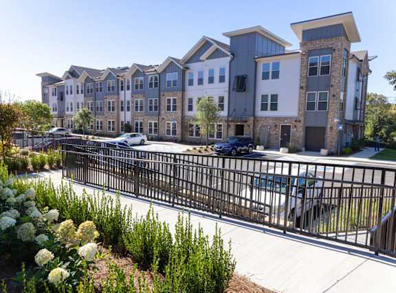 A row of modern townhouses with a black fence in front.
