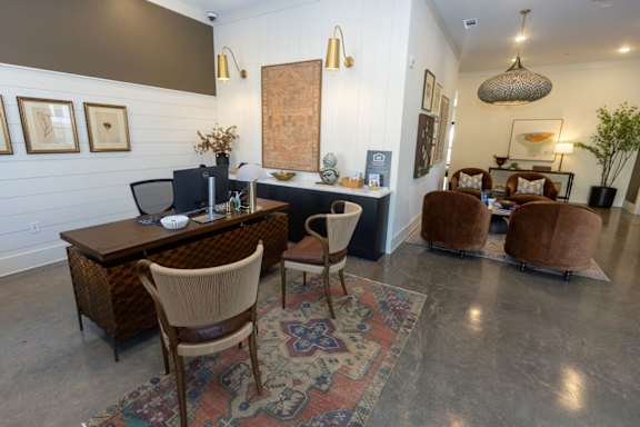 A room with a desk and chairs in it.