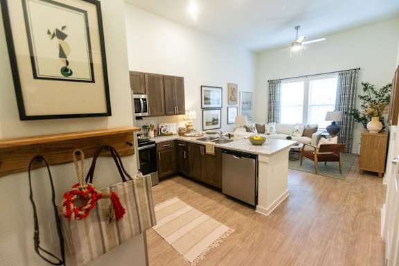 A kitchen with a white counter top and wooden floors.