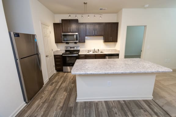 a kitchen with a island and a stainless steel refrigerator