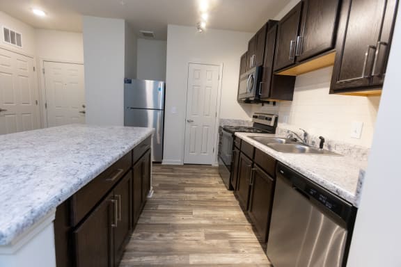 a kitchen with stainless steel appliances and marble counter tops