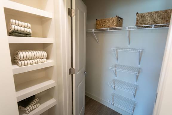A white closet with shelves and baskets.