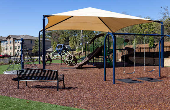 Walton Trail playground in Villa Rica A playground with a swing set and a bench.