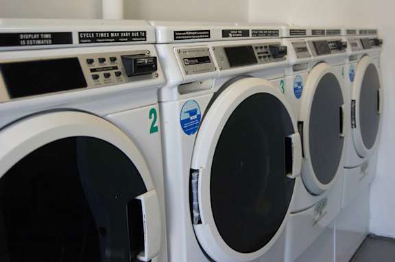 a row of washing machines in a public laundromat at Brookwood at Holbrook, Holbrook, NY, 11741