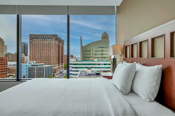A bedroom with a large bed and a view of the city.