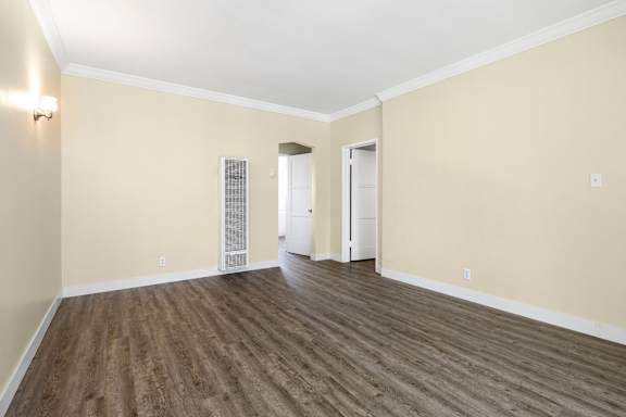 an empty living room with wood flooring and white walls