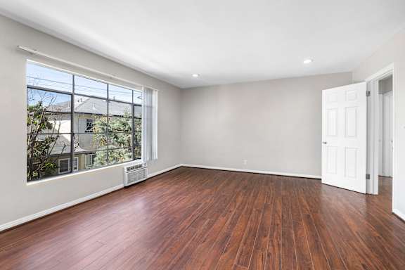 A room with wooden floors and a large window.