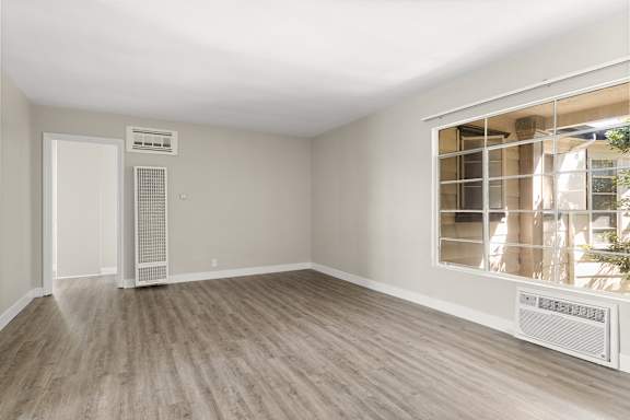 A room with a window and a wall-mounted air conditioner unit.
