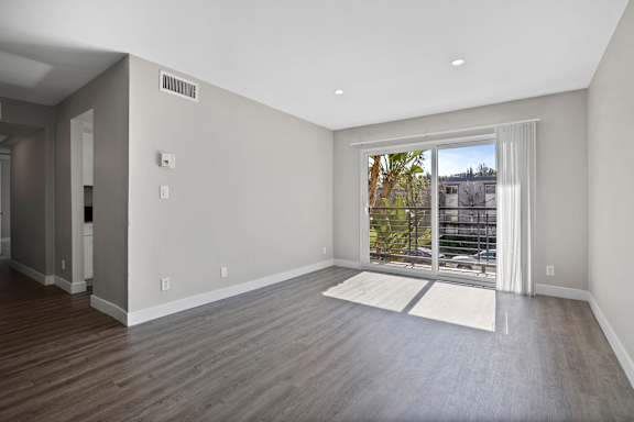 A room with a large window and a view of a parking lot.