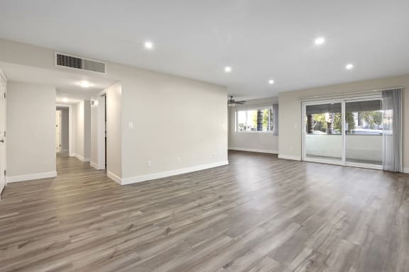 a renovated living room with white walls and wood flooring